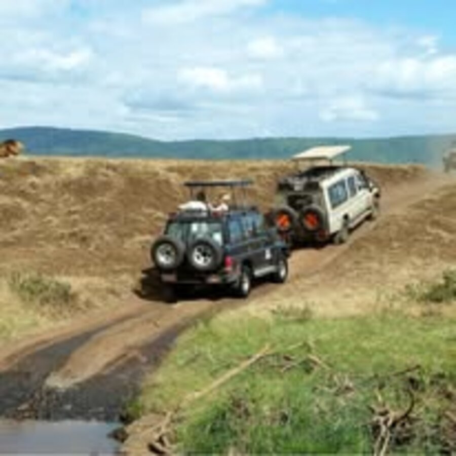 Safari vehicles crossing a river in Kenya